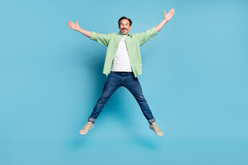 Obraz premium Full length body size view of attractive cheerful free man jumping having fun isolated over bright blue color background
