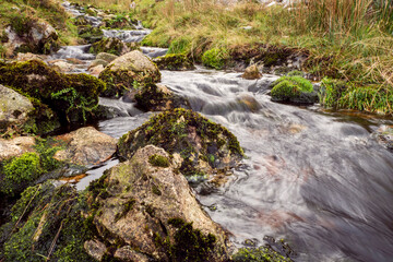 Small waterfall in a mountains. Beautiful nature scenery. Calm and peaceful atmosphere.