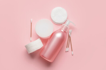 Care cosmetics, cotton buds and cotton pads on pink background