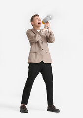 Angry teenage boy shouting into megaphone on white background