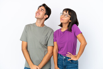 Fototapeta premium Young couple isolated on isolated white background posing with arms at hip and laughing