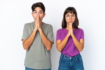 Young couple isolated on isolated white background keeps palm together. Person asks for something