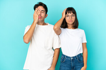Young mixed race couple isolated on blue background with surprise and shocked facial expression