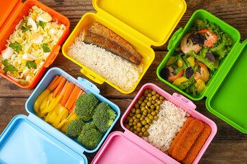 Many plastic containers with different healthy food on wooden background, closeup