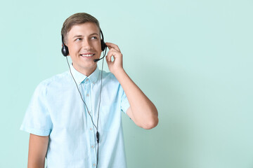 Young consultant of call center in headset on blue background