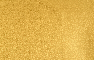 Festive fabric with small floral patterns in gold color. Background, abstraction, mass production to the general public