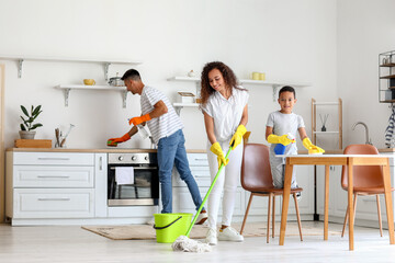 Happy interracial family cleaning kitchen