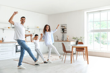 Happy interracial family dancing in kitchen