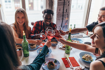 Friends Making Toast Around Table At Dinner Party