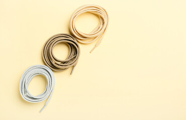 Rolls of different shoe laces on color background
