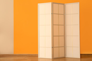 Modern folding screen near orange wall