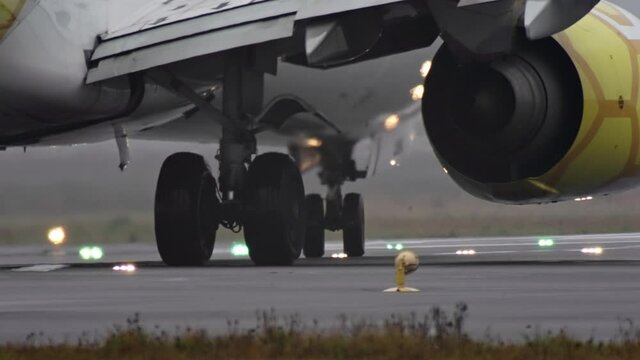 Close-up of the wheels of an airplane traveling on the runway. The plane is departing at the airport.