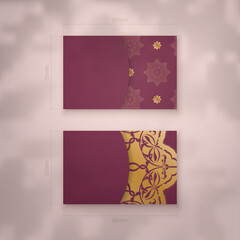 A presentable burgundy business card with an antique gold pattern for your contacts.
