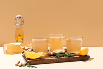 Glasses of natural kombucha with lemon, ginger and rosemary on table