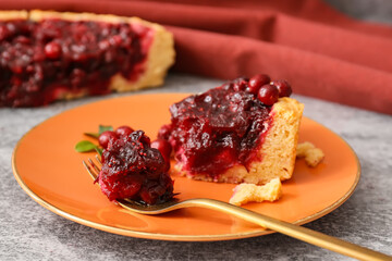 Piece of tasty lingonberry pie in plate on grey background, closeup