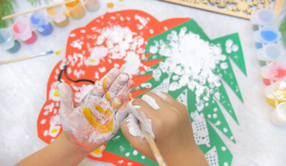 Child making a greeting card  Craft for children. Nice greeting card with a Christmas snowy forest. . Top view