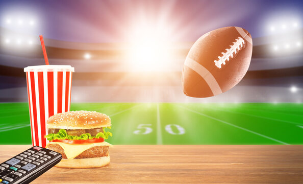 Burger And Coffee On Wooden Table . TV Broadcast Of American Football Background. Sport Bar Concept