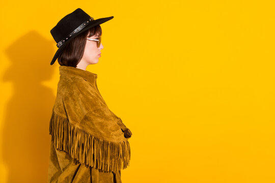 Photo of strong serious woman dressed cowboy clothes spectacles cap arms folded looking empty space isolated yellow color background