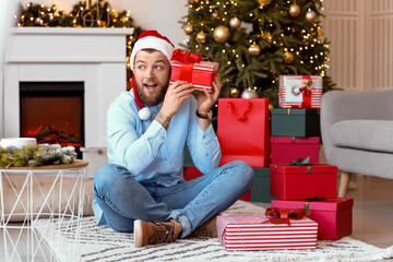 Handsome man with gifts at home on Christmas eve