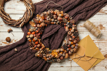 Beautiful acorn wreath with envelope on white wooden background