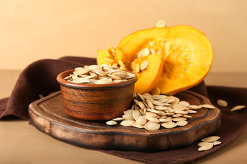 Bowl with natural pumpkin seeds on table