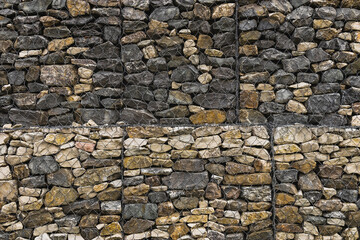 Gabions in landscape design as decorative elements and in the arrangement of terraces on the site. Wire gabions made of stones keep the walls from collapsing in a landscape project.