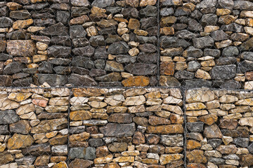 Wire gabions made of stones keep the walls from collapsing in a landscape project. Gabions in landscape design as decorative elements in the arrangement of terraces on the site.