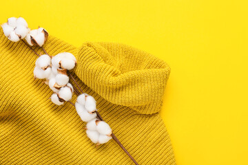 Cotton flowers and sweater on yellow background