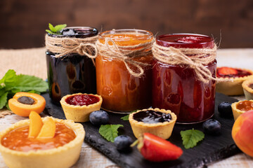 Jars with delicious summer fruits jam