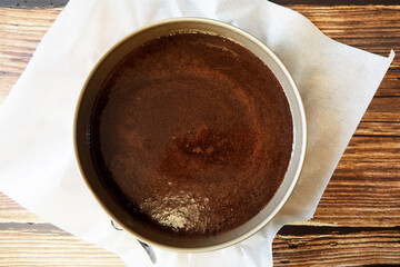 around a vegan raw brownie on parchment paper on a wooden table. before baking. top view. gluten- and lactose-free pastries