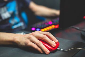Cyber sport e-sports tournament, team of professional gamers, close-up on gamer's hands on a keyboard and mouse, gamers playing in competitive moba, strategy fps game in a cyber games arena club