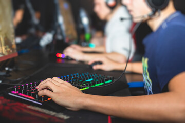 Cyber sport e-sports tournament, team of professional gamers, close-up on gamer's hands on a keyboard and mouse, gamers playing in competitive moba, strategy fps game in a cyber games arena club