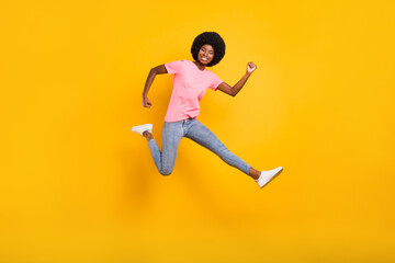 Fototapeta na wymiar Full size profile photo of active millennial lady jump wear pink t-shirt jeans isolated on yellow color background