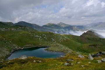 Fototapeta na wymiar Beautiful mountain lake, view above clouds during hiking on peak Djeravica (Gjerovica) - the highest peak of Kosovo. Albanian Alps, Peaks of Balkans