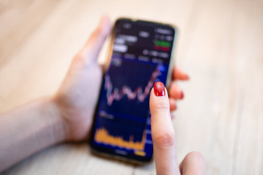 スマートフォンで投資をする女性の手