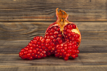 Red pomegranate on wooden background.