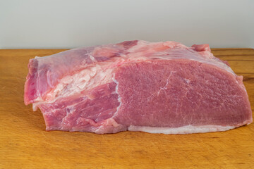 A piece of meat on a cutting board close-up.