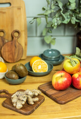 Auswahl an Obst auf Frettchen, in verschiedenen Schalen und Tellern auf Holzuntergrund mit Fliesenspiegel. Gesunde, vitaminreiche, vegane Ernährung, ethisch nachhaltiger Lebensstil, umweltfreundlich, 