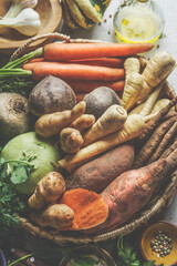 Close up of various raw organic root vegetables: Parsnip, sweet potato, carrots, kohlrabi and...