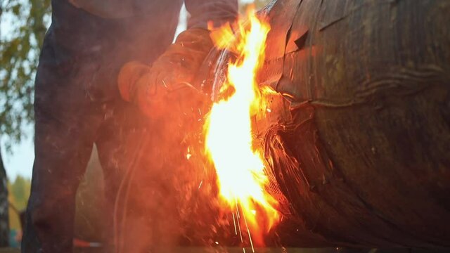 Video slow motion. Acetylene welding cuts a metal pipe in the open air. Metal cutting. A real non-staged scene. Industrial background.