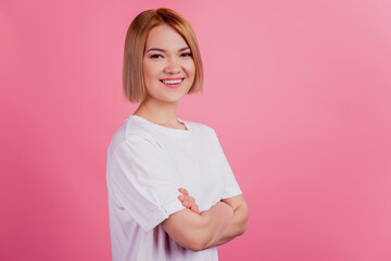 Photo of positive self-assured lady folded hands wear white t-shirt isolated on pink background