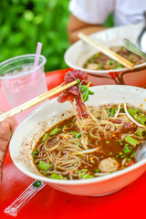 The chopsticks with the fermented raw beef signature of thai noodle blood soup at Wat Maprao Tia Temple in Bangkok Thailand