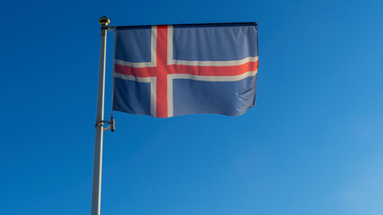 Iceland flag is on blue sky background. Flag of Iceland waving in the wind against the sky. Diplomacy concept.