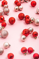 Decorative red and pink balls on a pink background. Top view, flat lay.