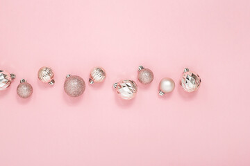 Decorative pink shiny balls on a pink background. Top view, flat lay.