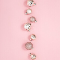 Decorative pink shiny balls on a pink background. Top view, flat lay.