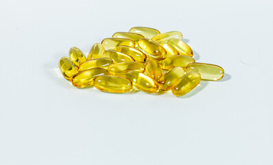 Close up yellow gel capsules with Omega 3 or vitamin a, d  on the white background. oil caps, vitamin, suplements	