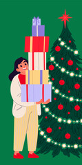 Girl holding pile of christmas gift boxes standing beside a decorated christmas tree.