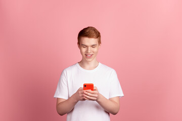Fototapeta na wymiar Photo of young man read post comment cellphone like follow subscribe isolated over pink color background