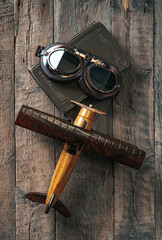Aviation concept with toy airplane, aviator glasses and flight book. Vertical composition.